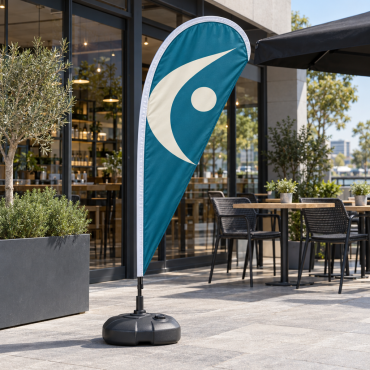 Teardrop promotional flag with an abstract design on a stable base outdoors