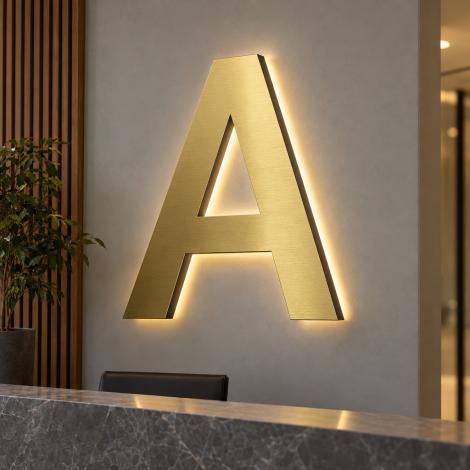Letra A luminosa em Dibond dourado acetinado e metacrilato, instalada numa parede de receção