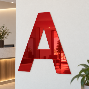 Versalt A i 3 mm röd spegelakryl, placerat på en ljus vägg i en receptionsmiljö.