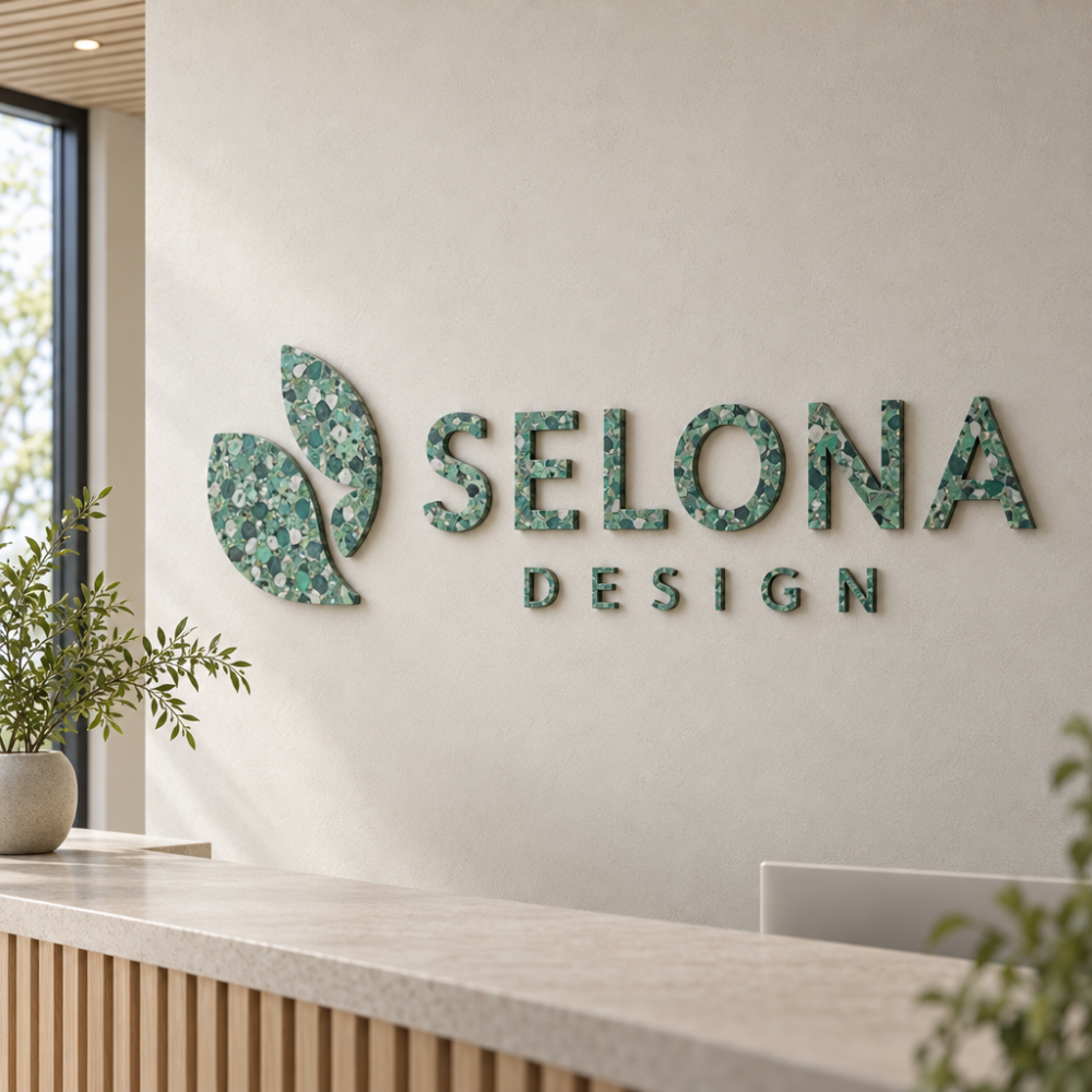 Sienas izkārtne no pārstrādātas plastmasas ar abstraktu simbolu un reljefā veidotiem uzrakstiem SELONA un DESIGN pieņemšanas